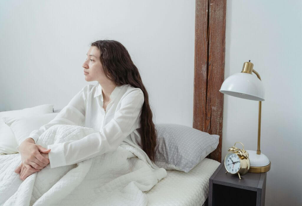 a woman sitting in her low tox bedroom