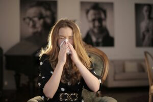 woman sneezing into a napkin because of mold toxicity