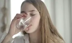 a woman drinking water from a glass