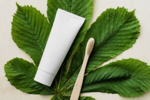 natural toothpaste and toothbrush on a leaf background